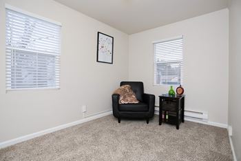 an empty living room with a black chair and a side table  at Woodhaven, Everett, 98203
